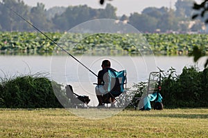Back view of a fisherman on the lake of Mantua