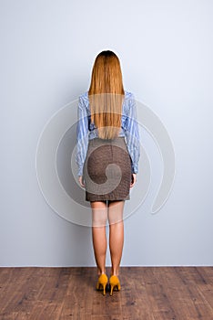 Back view full length portrait of blond business lady in formal