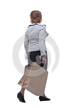 Back view full length portrait of a Senior woman walking with shopping bags