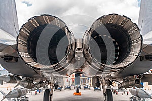 Back view of the giant powerful round engines of a military fighter jet in the airport