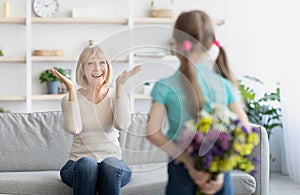 Back view of girl greeting woman with flowers