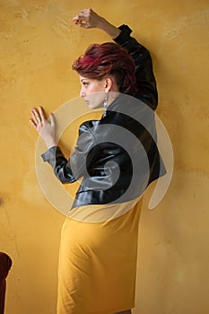 Back view of glamorous lady in punk rock style party clothes with dark pink hair in casual dress, black leather jacket