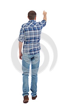 Back view of going handsome man in jeans pointing.