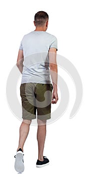 Back view of going handsome man in shorts