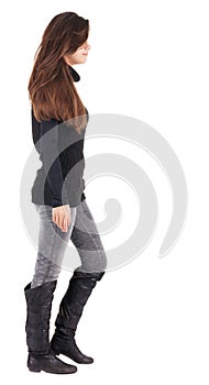 Back view of going woman in jeans and sweater