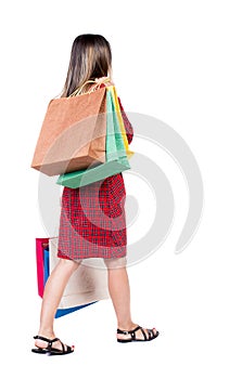 Back view of going woman with shopping bags . beautiful girl i