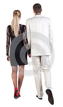 Back view of going young business couple (man and woman) .