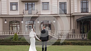 Back view of groom and bride walking to the palace