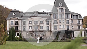 Back view of groom and bride walking to the palace