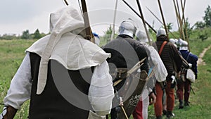 Back view of group medieval knights going on the battle.