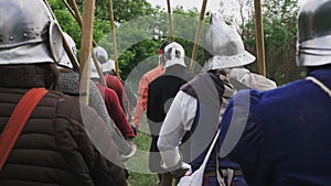 Back view of group medieval knights going on the battle.