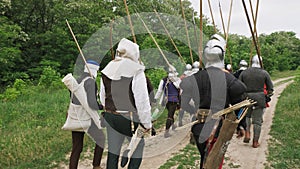 Back view of group medieval knights going on the battle.