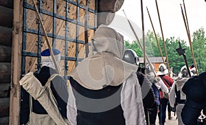 Back view of group medieval knights going to the exit from fortrees on the battle.