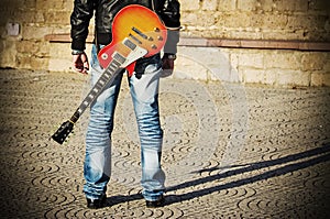 Back view of a guitarist standing with a guitar