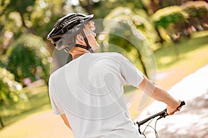 Back view of guy in helmet on bicycle