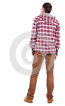 Back view of guy in a plaid shirt with hood looking.