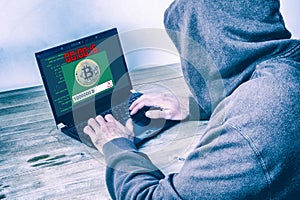 Back view of a hacker stealing bitcoins