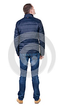 Back view of handsome man in blue windcheater looking. photo