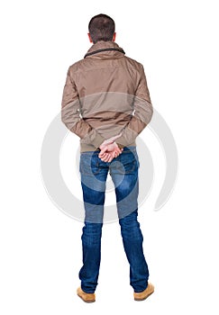 Back view of handsome man in brown windcheater looking up. photo