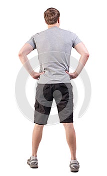 Back view of handsome man in t-shirt and shorts looking up