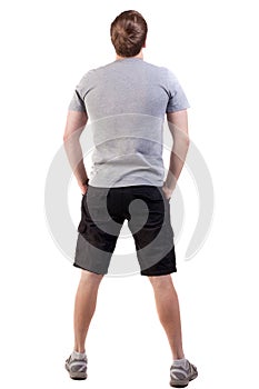Back view of handsome man in t-shirt and shorts looking up
