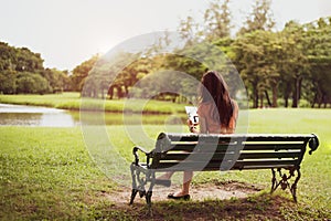 Back view of happy beauty woman in casual outfits using tablet in national park background. People lifestyles and technology