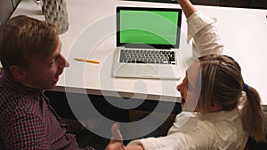 Back view: happy excited couple man and woman using laptop with green screen chromakey at home, happy couple received