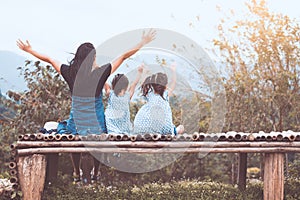 Back view of happy family mother and two child girls sitting