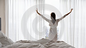 Happy young woman stretch in bed welcoming new day