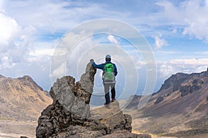 Back view of a hiker with a green backpack on top of the Iztaccihuatl volcano