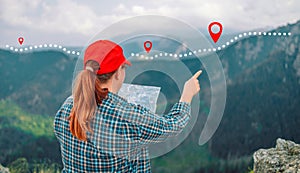 Back view of hipster girl wanderlust rest during hiking sitting with map looking at mountains far away