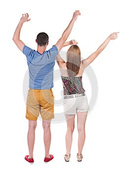 Back view of joyful couple celebrating victory hands up.