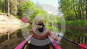 Back view Kayaking couple in river.POV of woman and man kayaking in Zemeina river, Lithuania. Aquatic sports during summer