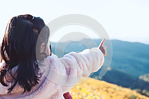 Back view of little asian child girl put on coat raise her arm