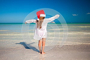 Back view of Little cute girl in red hat santa