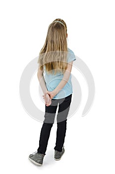 Back view of little girl looking at wall. Rear view. Isolated on white background