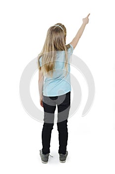 Back view of little girl points at wall. Rear view.