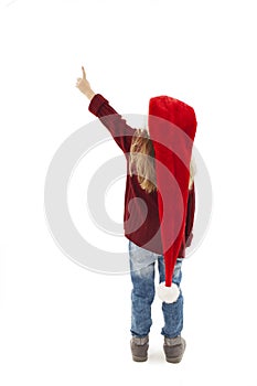 Back view of little girl in red Santa hat pointing at wall. Rear view