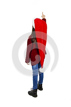 Back view of little girl in red Santa hat pointing at wall. Rear view