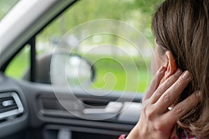 Back view of lonely girl touching by hand rainy window with drop of car.