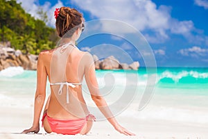 Back view of long haired woman in bikini on tropical beach