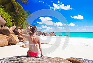 Back view of long haired woman in bikini on tropical beach