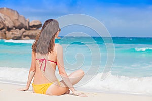 Back view of long haired woman in bikini on tropical beach