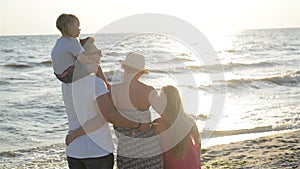 Back View of Lovely Parents and Two Daughters Spending Time Together near the Sea During Sunset. Handsome Father Holding