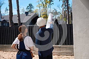 Back view male architect showing something to woman engineer