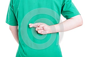 Back view of male doctor holding fingers crossed