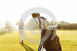 Back view of a male golfer swinging golf club