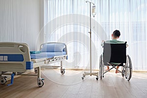 Back view, Male patient having stressed or boring and sitting on wheelchair