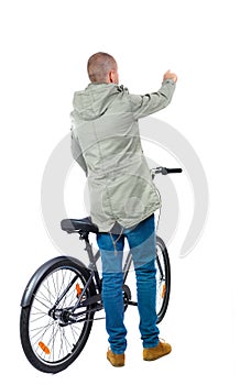 Back view of a man with a bicycle.