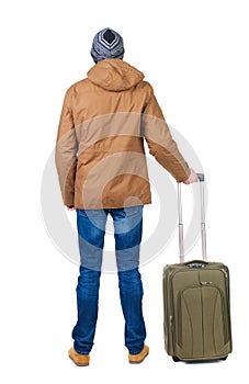 Back view of man in a brown jacket with suitcase .
